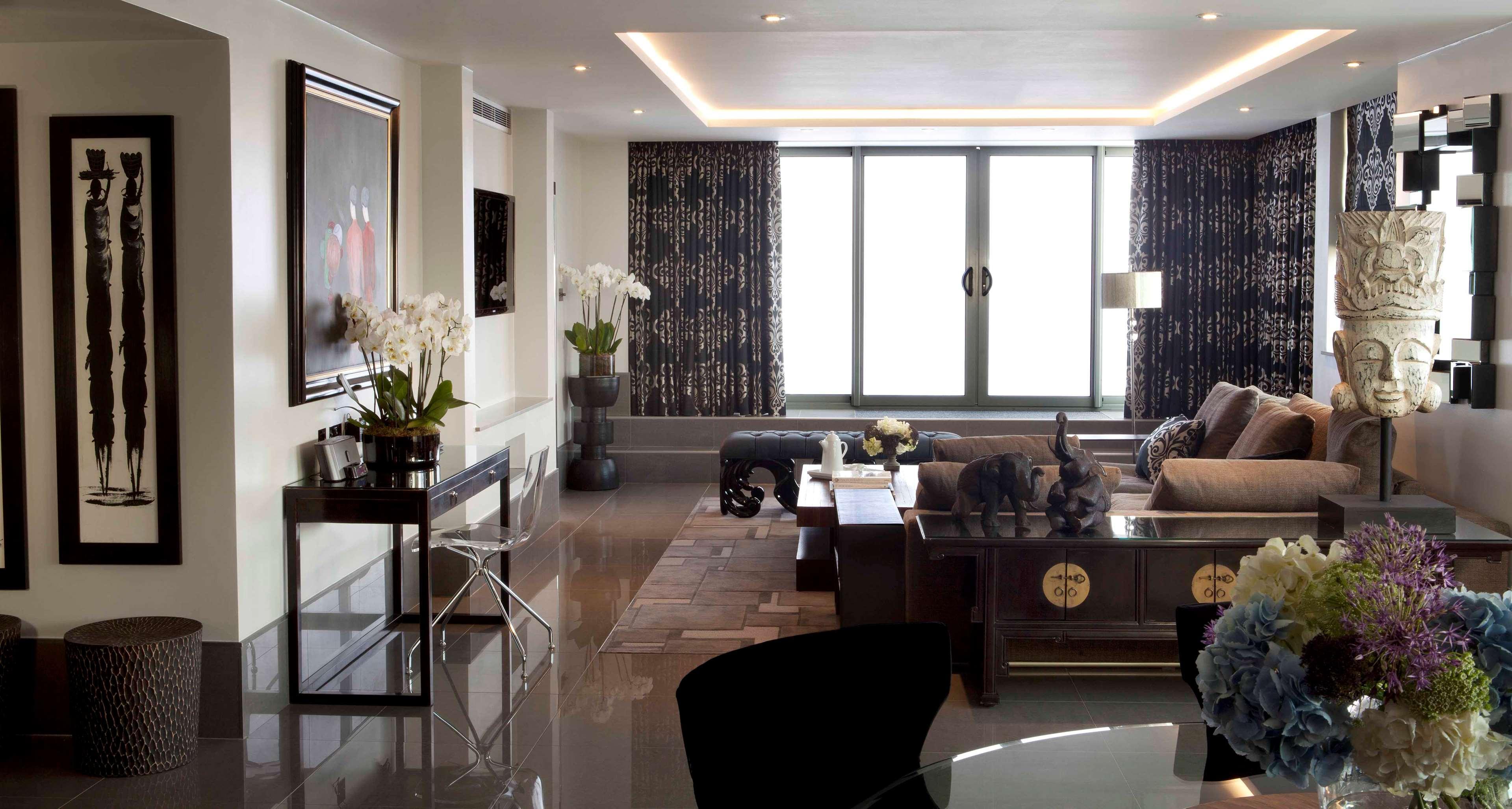 The May Fair, A Radisson Collection Hotel, Mayfair London Exterior photo The photo depicts an elegantly designed interior space, likely a living room. It features:

- A large window with modern curtains that allow natural light to filter in.
- A contemporary sofa, complemented by decorative pillows, situated around a coff